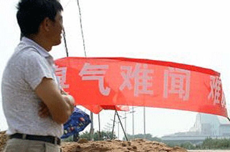 7月17日，武漢居民抗議垃圾發電廠垃圾車常年擾民，高舉自制橫額堵路抗議。（居民提供）