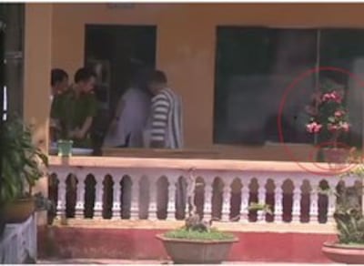 Cảnh quay Cảnh quay 2-2-58 TS Cù Huy Hà Vũ đang bước vào phòng y tế, có chậu cây đang nở hoa. Screen capture.