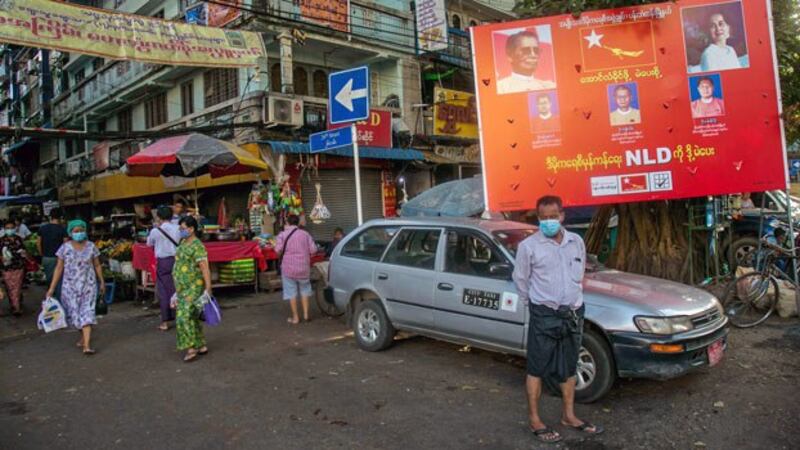 People walk past an election campaign poster for the National League for Democracy party in Myanmar's commercial hub Yangon, Sept. 15, 2020.