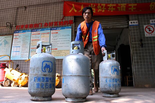 한 근로자가 광저우의 LPG 주유소에서 액화 석유 가스(LPG)를 옮기고 있다. 