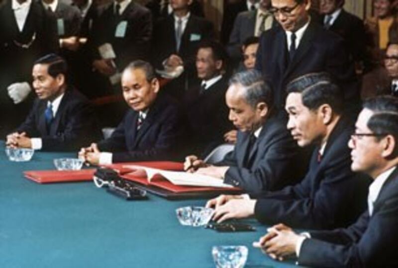 Ông Nguyễn Duy Trinh (giữa), đại diện Bắc Việt Nam, ký thỏa thuận ngừng bắn cuộc chiến Việt Nam, ảnh chụp ngày 27 tháng 1 năm 1973 tại Paris.