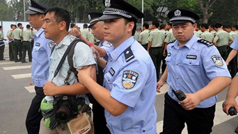 2008年7月25日，香港多家媒体采访北京开售奥运门票的混乱情况时，多名记者被公安粗暴对待，图为《南华早报》摄影记者被数名公安押带。（AFP） 