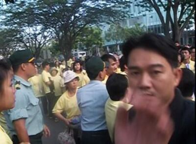 Nhân viên an ninh mặc thường phục dơ tay chụp máy quay phim. RFA file