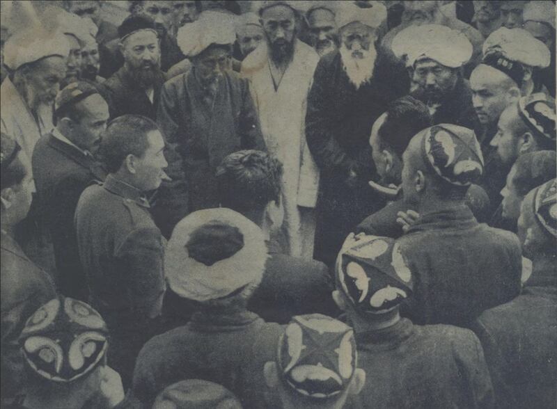 ئەخمەتجان قاسىمى (سول تەرەپ ئوتتۇرىدىكى دوپپىلىق كىشى)، جاڭ جىجۇڭ (سول تەرەپ ئوتتۇرىدىكى ھەربىي فورمىلىق كىشى)، ئەيسا يۈسۈپ ئالپتېكىن (ئوڭ تەرەپ ئوتتۇرىدىكى يالاڭباشتاق كىشى) ۋە ئابدۇكېرىمخان مەخسۇم (سول تەرەپ سەللىلىك ئاق ساقال كىشى) قاتارلىقلار قەشقەر خەلقى ئارىسىدا، 1947-يىل ماي، قەشقەر