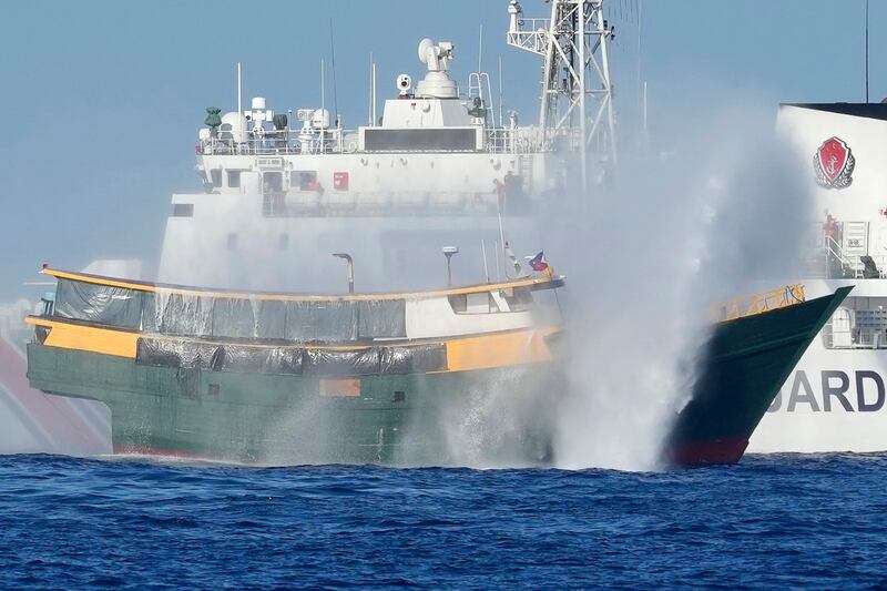 The Philippine resupply vessel Unaizah May 4 (foreground) is hit by two Chinese coast guard water cannons as it tries to enter the Second Thomas Shoal, locally known as Ayungin Shoal, in the disputed South China Sea, March 5, 2024. (Aaron Favila/AP)