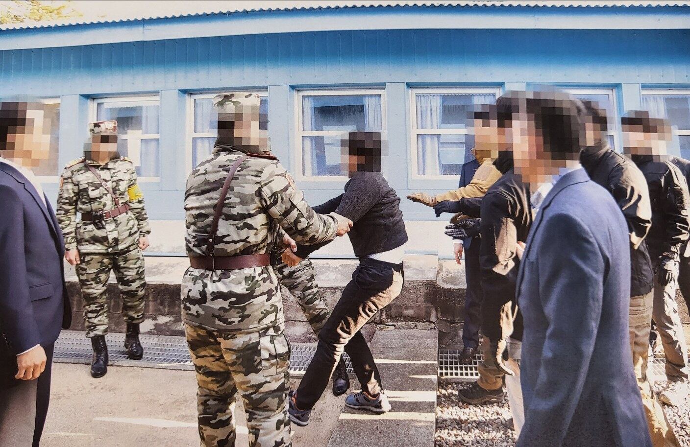 한국 통일부는 지난 2019년 11월 판문점에서 탈북어민 2명을 북한으로 송환하던 당시 촬영한 사진을 12일 공개했다. 당시 정부는 북한 선원 2명이 동료 16명을 살해하고 탈북해 귀순 의사를 밝혔으나 판문점을 통해 북한으로 추방했다. 사진은 탈북어민이 몸부림치며 북송을 거부하는 모습.
