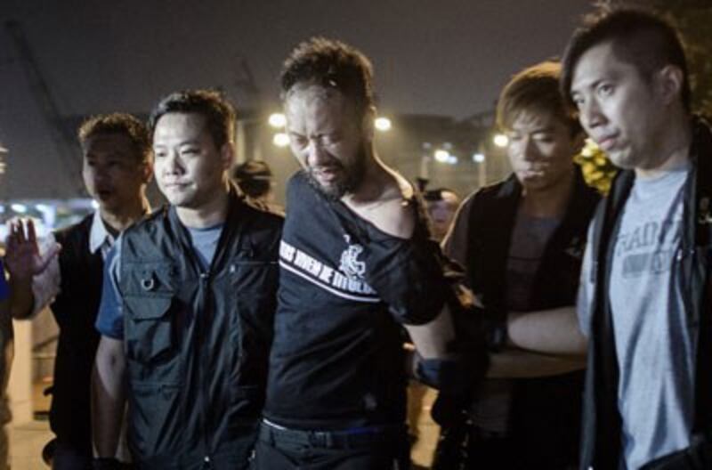 Ken Tsang is taken away by policemen before being allegedly beaten up by police forces outside the central government offices in Hong Kong, Oct. 15, 2014. Credit: AFP