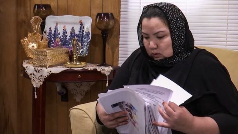 来自新疆的维吾尔人Zumret Dawut在美国弗吉尼亚的家里展示新疆实行强制计划生育的资料。（美联社）
