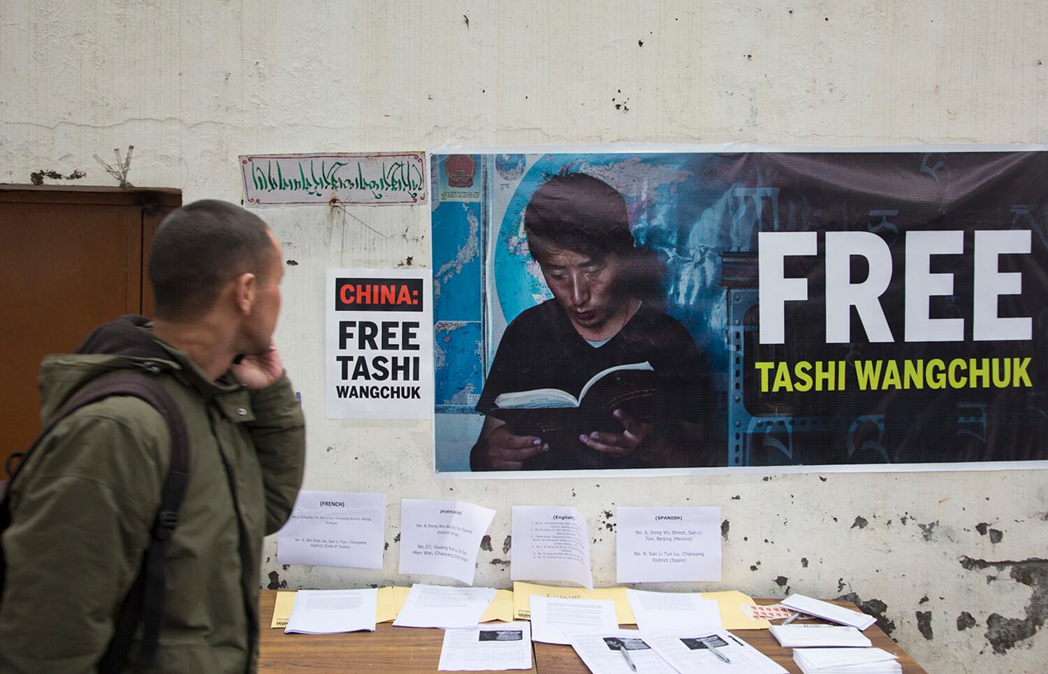 A man walks past a banner in Dharmsala, India, Jan. 27, 2017, demanding the release of Tibetan rights activist Tashi Wangchuk after his arrest in 2016.