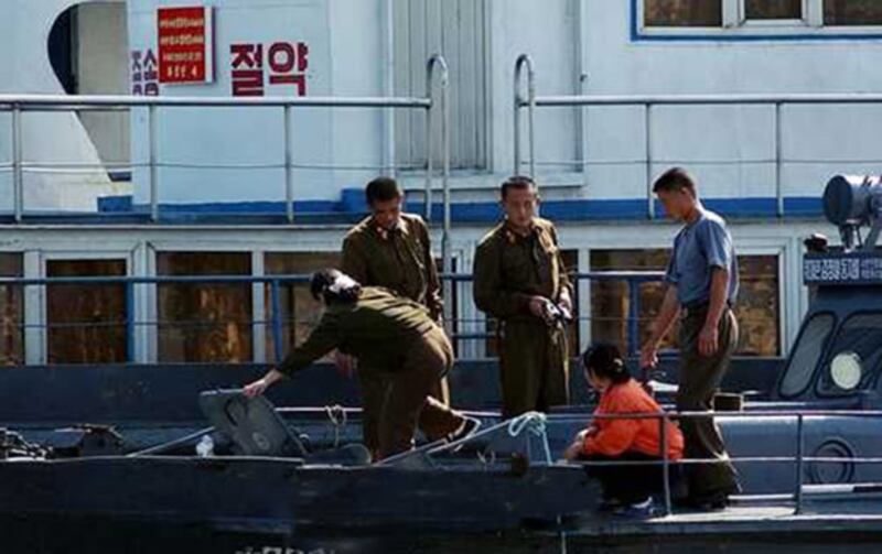 북한 신의주항 인근에서 북측 병사들이 배를 검색하고 있다. 
