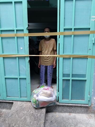 Ảnh minh họa. Một người dân khu phong toả, cách ly, dãy trọ F0 ở TP.HCM nhận quà cứu trợ từ mạnh thường quân vào ngày 1/9/2021.Facebook Đêm Sài Gòn.