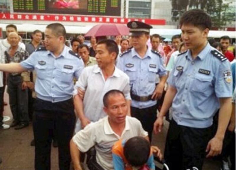 警方將陳芽監護人陳風強及4名維權人士帶走，陳芽坐在蕭青山輪椅，一併被帶到派出所。（現場人士提供） 