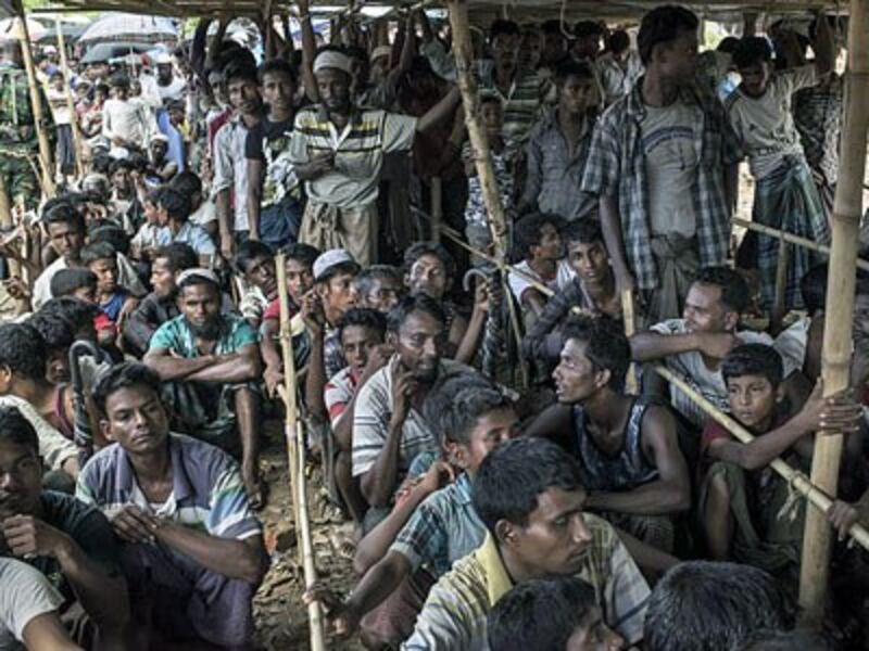 Rohingya refugees wait in line during a food distribution at the Thangkhali refugee camp in Ukhia, Cox's Bazar district, in southeastern Bangladesh, Oct. 10, 2017.