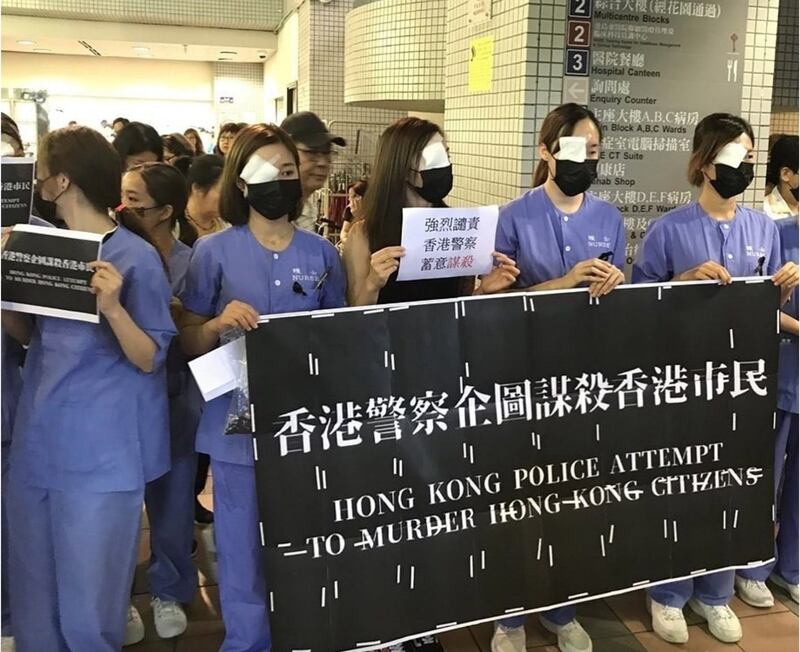 香港医护抗议“警察滥用武力，政府漠视民意”，参与者戴上黑口罩、以纱布遮眼，声援2019年8月11日右眼重伤的女示威者。（图/范国威脸书）