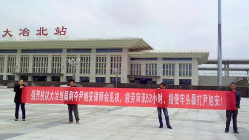 2015年4月8日，尹旭安的聲援者在離開大冶市時，拉橫幅抗議當局的違法行為。(王芳提供)