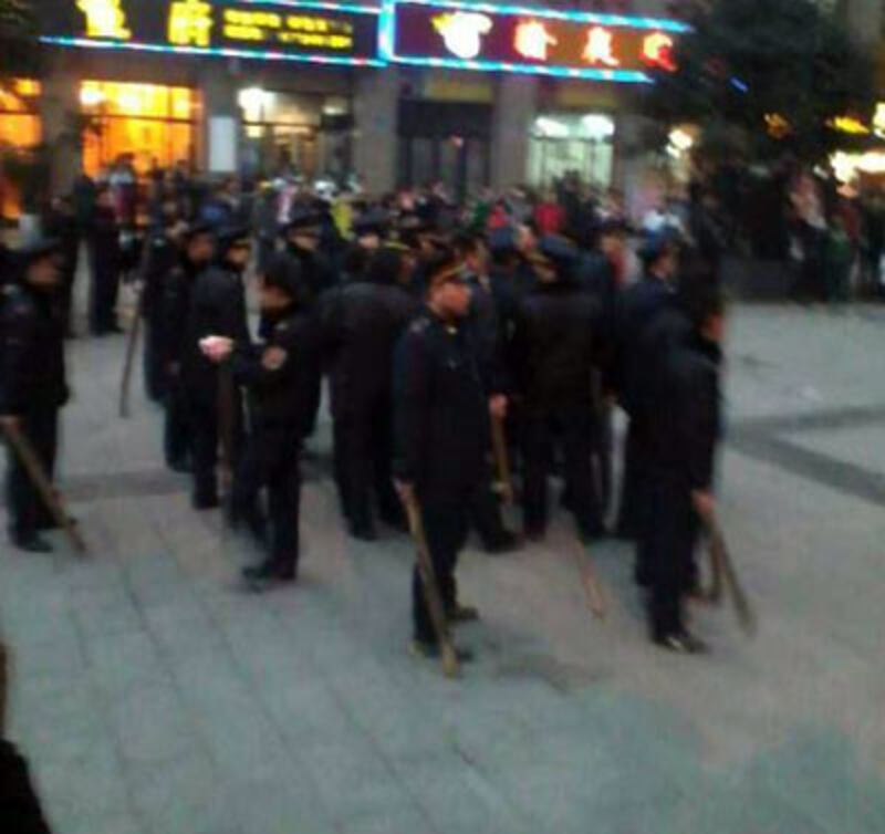 1月19日，重慶市沙坪垻區城管手持木棍、耕作用的銼刀、磚頭等，追打在場小販。（商戶攝）