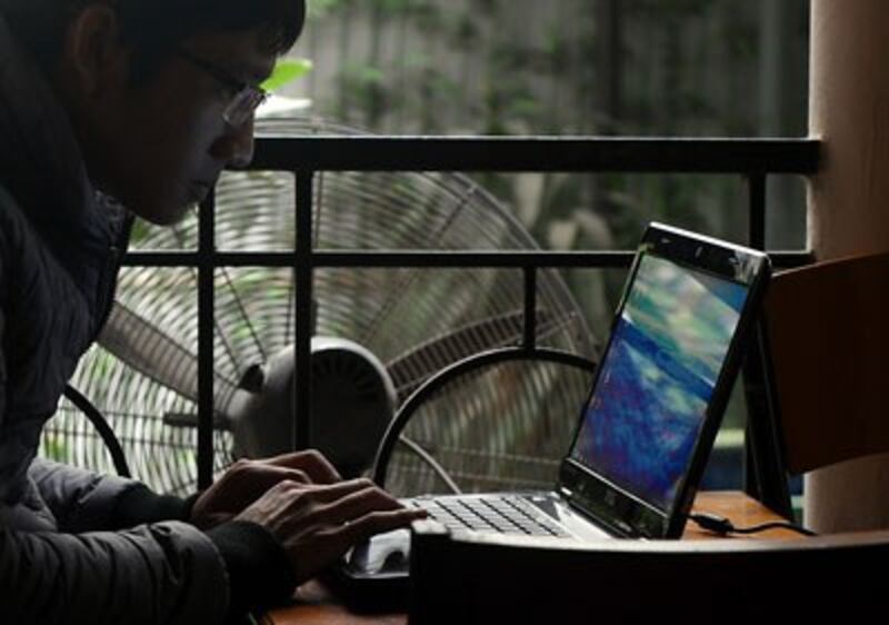 Một người dân sử dụng laptop lướt web trong một quán cà phê ở Hà Nội hôm 28/11/2013. 