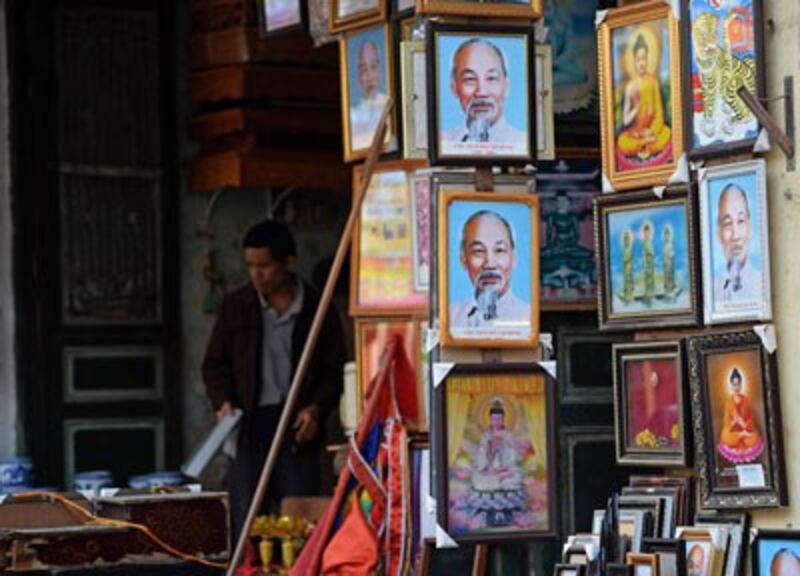Hình cố chủ tịch Hồ Chí Minh được bày bán cùng các hình ảnh về tôn giáo tại một cửa hàng ở Hà Nội ngày 08 tháng 12 năm 2015. AFP photo