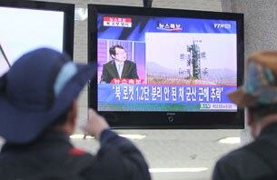 북한이 광명성 3호 위성을 탑재한 은하 3호 로켓 발사를 강행한 13일 오전 인천시 중구 인천연안여객터미널에서 여행객들이 로켓 발사 소식을 전하는 TV뉴스를 보고 있다.