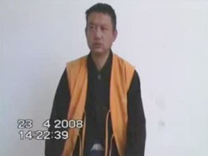 图片：原西藏拉萨哲蚌寺僧人洛桑旺秋接受当局的审讯。（视频截图）