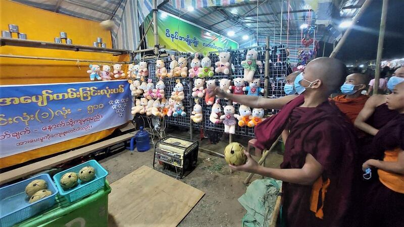 မန္တလေးတိုင်း ညောင်ဦးမြို့ ရွှေစည်းခုံဘုရားအနီးတွင် ရောင်းချနေသည့် ဆယ့်နှစ်ပွဲစျေးသည်များနှင့် ပွဲဈေးလာသူများကို ၂၀၂၃ ခုနှစ် ဇွန်လ ၁ ရက်နေ့ညက တွေ့ရစဉ်။ (Photo: RFA)
