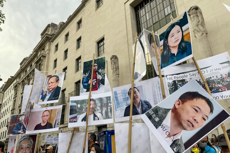 倫敦中國大使館外的六四集會，有參加者展示香港政治犯相片，呼籲毋忘香港政治犯。（呂熙 攝）