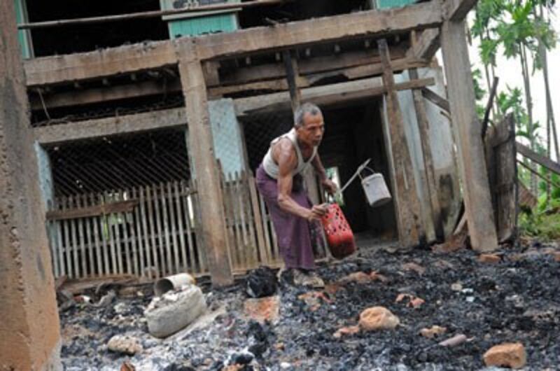 A man salvages items from the burnt area of a mosque following communal clashes in Thabyuchine village in Rakhine state, Oct. 2, 2013. Credit: AFP