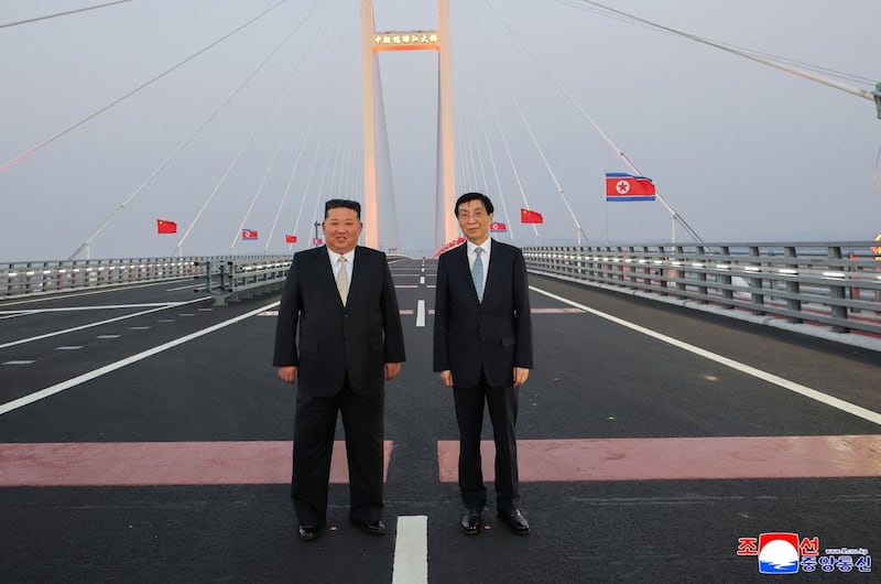 2026년 10월 24일, 김정은 북한 국무위원장이 중국 랴오닝성 단둥의 북중 압록강대교에서 왕후닝 중국 공산당 중앙정치국 상무위원 겸 전국인민정치협상회의 주석과 기념사진을 촬영하고 있다.