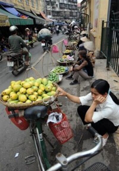 Người buôn gánh bán bưng trong một ngõ hẻm ở Hànội. AFP 