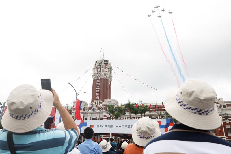台灣空軍在總統府上空盤旋匯演,吸引大批民眾觀賞。(路透社圖片)