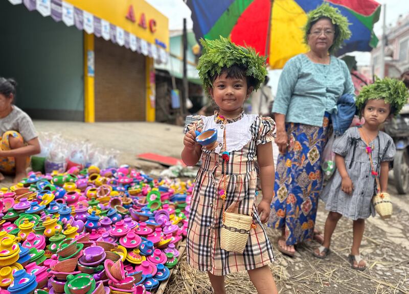 ၂၀၂၃ ခုနှစ် သြဂုတ်လ ၂၄ ရက်နေ့က မန္တလေးတောင်ခြေအနီး အောင်မြေသာစံမြို့နယ် အိုးဘိုရပ်ကွက်မှာ ကျင်းပတဲ့ အိုးပုတ်ပွဲတော်မှာ လာရောက်ဈေးဝယ်တဲ့ ကလေးတစ်ဦးကို တွေ့ရစဉ်။ (Photo : RFA)