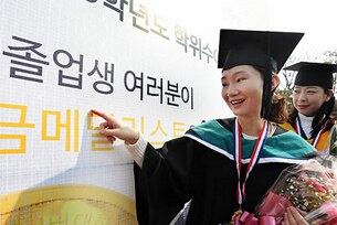 서울사이버대학교에서 열린 '2013학년도 서울사이버대학교 학위수여식'에서 졸업생들이 포토월에 적힌 이름을 찾아보고 있다.