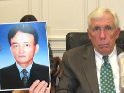 Dân biểu Frank Wolf và ảnh của nạn nhân anh Nguyễn Thành Năm