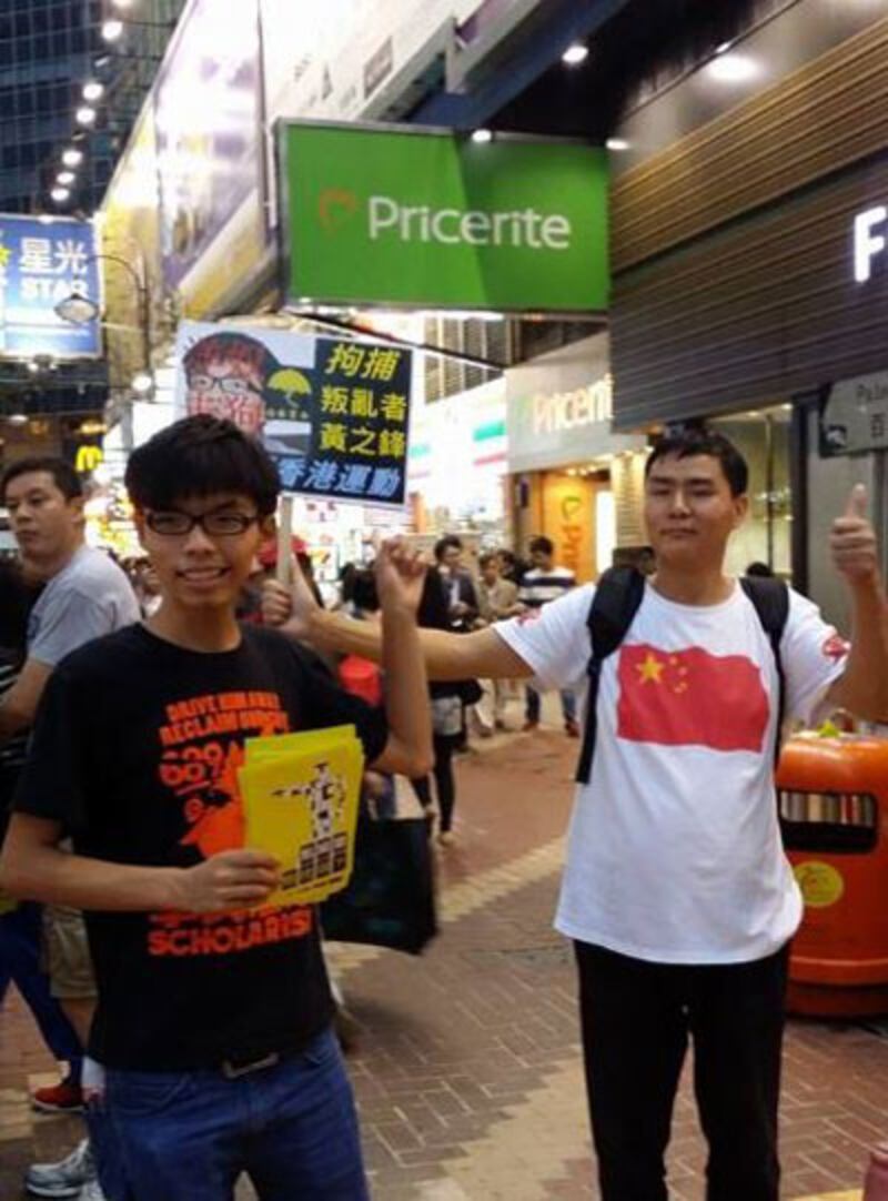 2014年11月16日，學民思潮召集人黃之鋒到銅鑼灣百德新街的街站宣傳政改，有反佔領者舉牌狙擊。（學民思潮提供）