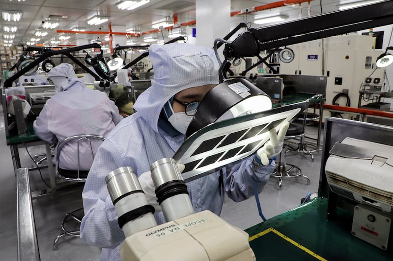A worker inspects semiconductor chips at the Unisem Berhad plant in Ipoh, Malaysia, Oct. 15, 2021.