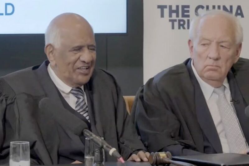 Judge Zak Yacoob (L) speaks with presiding judge Stephen Rapp during the China Tribunal at the Court of the Citizens of the World, in The Hague, the Netherlands, July 12, 2024. (Court of the Citizens of the World via YouTube)