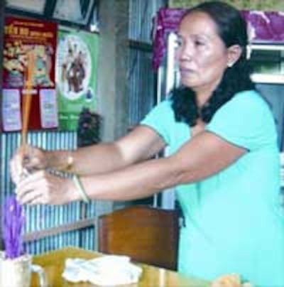 Mẹ của Hoàng Ngọc thắp hương cho con gái. Photo courtesy of thanhnien.com.vn
