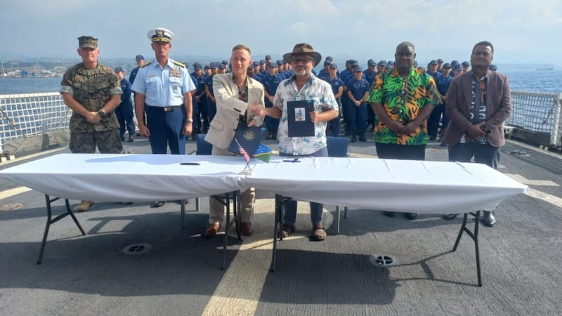 Solomon Islands Prime Minister Matthew Wale (front right) and Chargé d'Affaires P. Daniel O'Hara of the U.S. Embassy sign a shiprider agreement aboard the visiting U.S. Coast Guard Cutter Harriet Lane off the coast of Honiara, July 28, 2026.