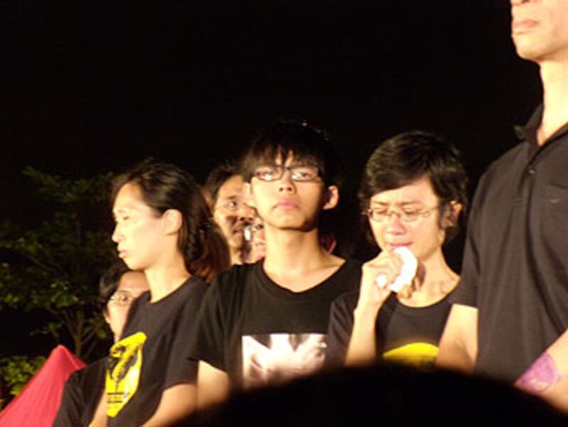 學民思潮的黃之鋒(左而),家長關注組的陳惜姿(右二)在週六晚(9月1日)的反國民教育集會上,獲悉再有十名大聯盟成員接力開始絕食支持學生,兩人在台上忍不住哭起來。 (劉雲拍攝)