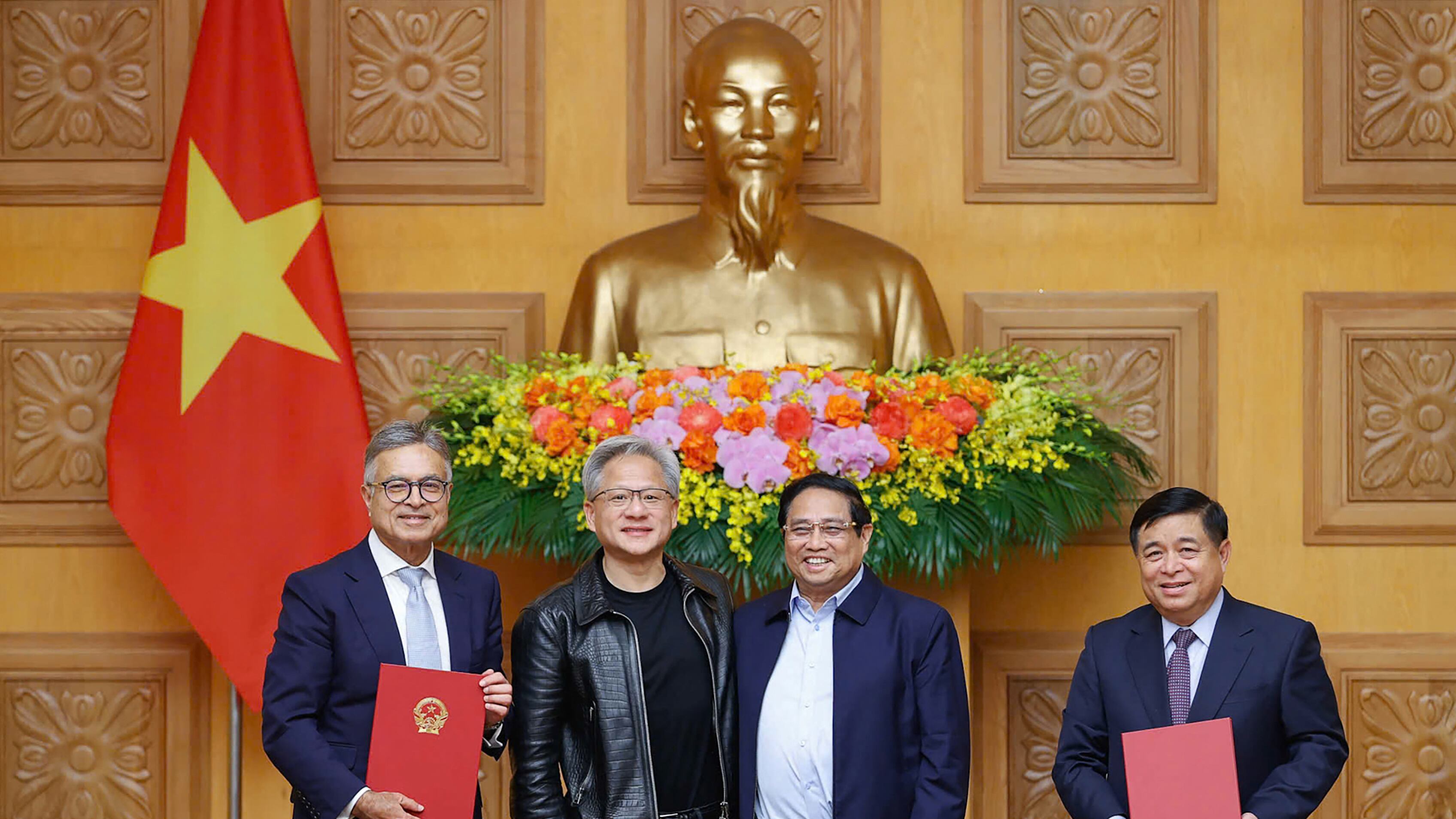Vietnam’s Prime Minister Pham Minh Chinh (2nd R) poses for photos with Jensen Huang (2nd L) during a meeting at the Government Office in Hanoi on Dec. 5, 2024.