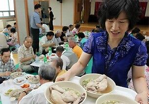 지난달 19일 서울 마포구 성산2동 주민센터에서 한 관계자가 어르신들께 삼계탕을 대접하고 있다.