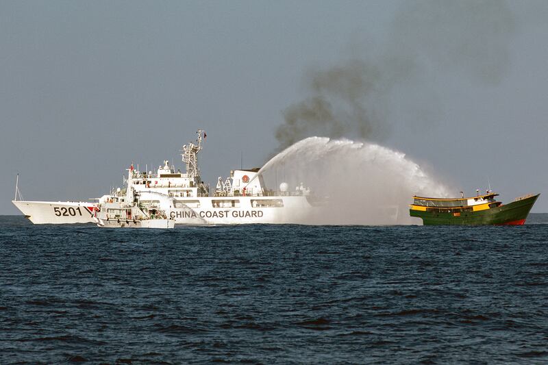 Chinese Coast Guard vessels fire water cannons toward a Philippine boat, right, on a resupply mission to a Philippine military outpost at Second Thomas Shoal in the South China Sea, March 5, 2024.