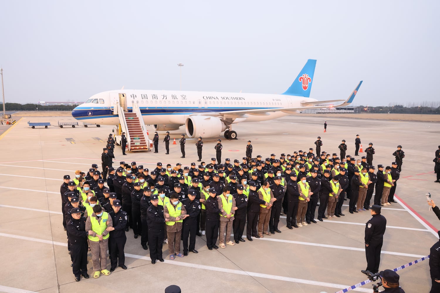 In this Feb. 20, 2025, image released by the Chinese government, a group of 200 Chinese citizens suspected of involvement in scam centers are returned to Nanjing, China under the escort of Chinese police after being repatriated from Myawaddy in Myanmar.