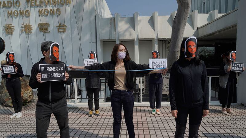 资料图片：2021年1月28日，香港公共广播电台（RTHK）员工戴着新闻工作者利君雅（Nabela Qose）的面具，管理层对利君雅的对待进行无声抗议。 利君雅现为香港电台助理节目主任及香港电台电视部节目《视点31》主持人。 （AP）