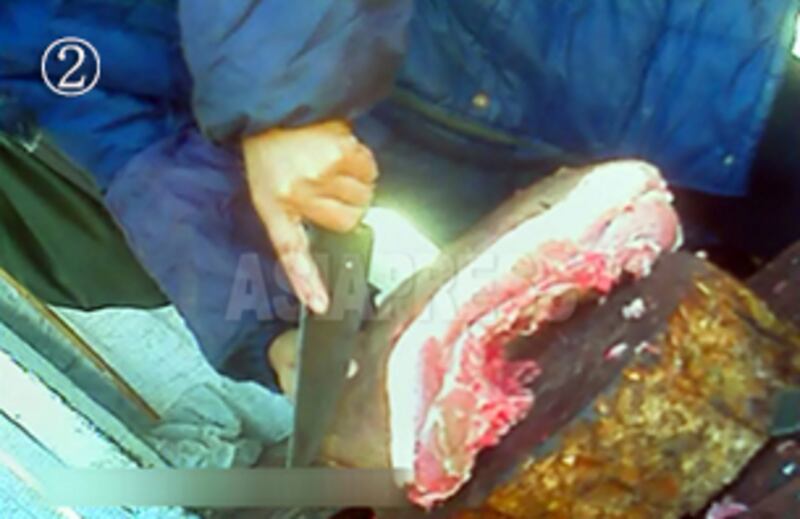 돼지고기를 자르고 있는 장사꾼. 이미 절단된 고기도 있으나, 고객이 요구하는 부위나 무게에 맞춰 잘라 준다. 사진-아시아프레스 제공