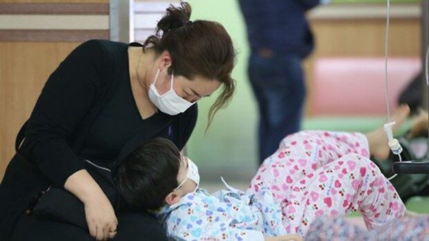 서울 용산구 소화아동병원에서 독감으로 입원 중인 한 어린이가 엄마의 보살핌을 받고 있다.