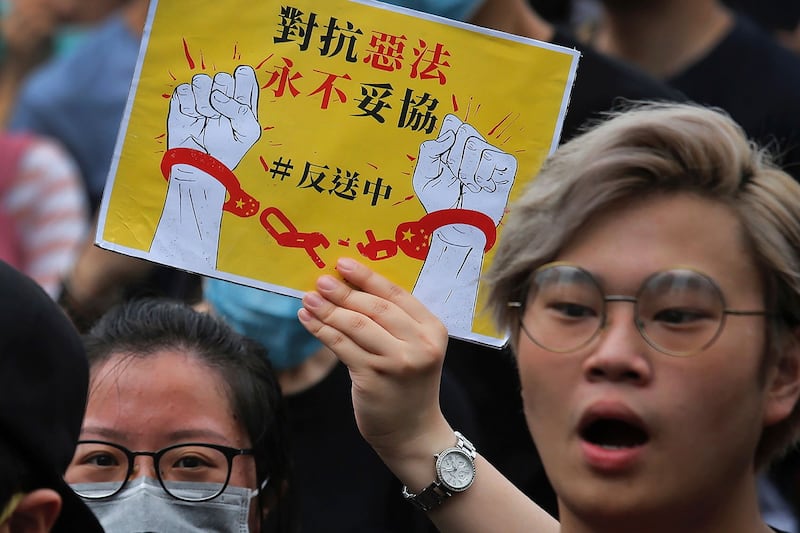 2019年6月17日,香港市民示威游行,示威群众手持标语“对抗恶法 永不妥协 反送中”。(美联社)