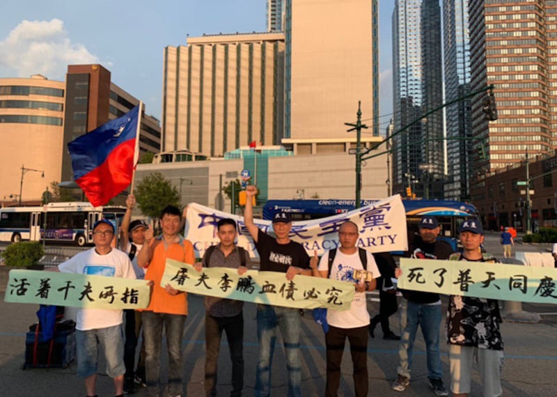 李鵬逝世後旅居美國的八九學運前學生領袖周鋒鎖(前排左二)及其他民主人士到紐約中領館前打出橫幅,要求追究李鵬六四屠城之責。(周鋒鎖推特圖片 / 拍攝日期不詳)