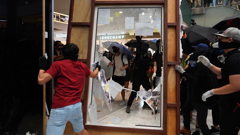 香港抗议者在捣毁一个广告牌。（美联社）