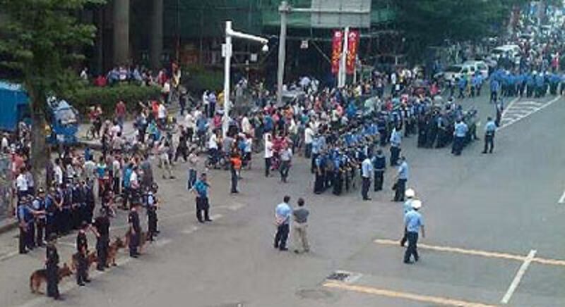工人堵塞廠房外道路討薪,當局出動大批警察和多頭警犬到場戒備。(現場人士提供)